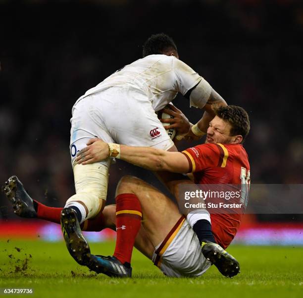 Nathan Hughes barges through the tackle of Dan Biggar of Wales during the RBS Six Nations match between Wales and England at Principality Stadium on...