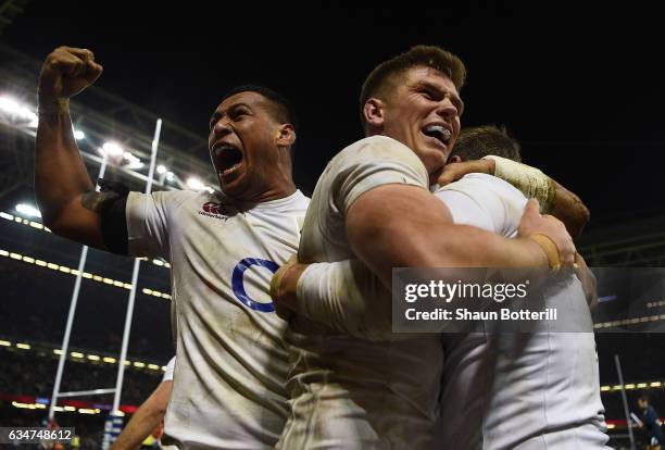 Elliot Daly of England is congratulated by teammates Nathan Hughes and Owen Farrell of England after scoring the match winning try during the RBS Six...