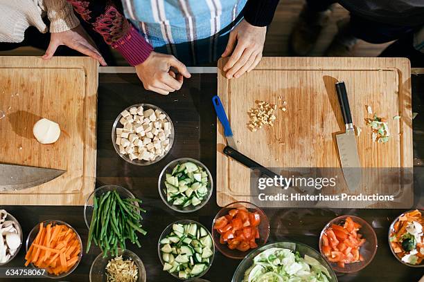 wooden cutting board with bowls and vegetables - tabla de cortar fotografías e imágenes de stock