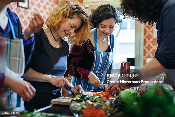 cooking class participants enjoy cutting vegetable - cook fotografías e imágenes de stock