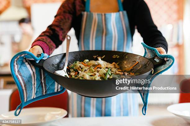 cooking wok filled with a steamy dish - wok stockfoto's en -beelden