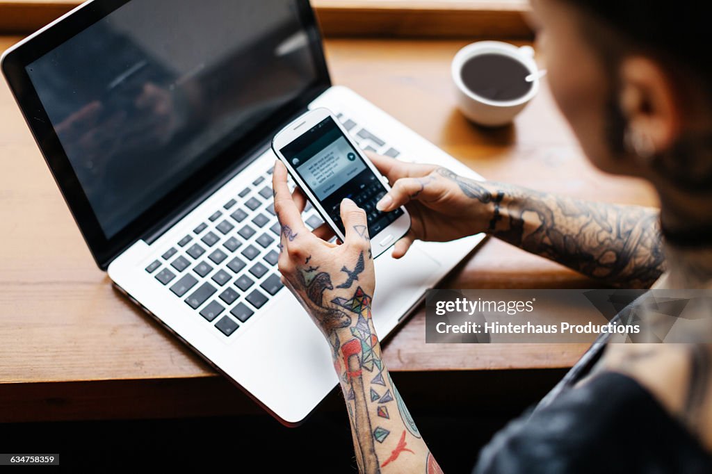 Tattooed woman checking her smart phone