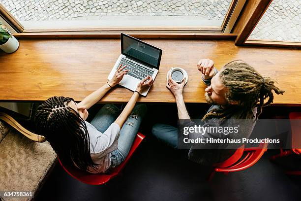 a young man and woman in a café - cafe business fotografías e imágenes de stock