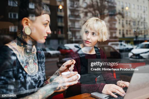 two young women talking in a café - 2 frauen gespräch ohne männer cafe stock-fotos und bilder