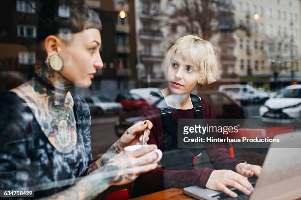 two young women talking in a café - berlin cafe stock pictures, royalty-free photos & images