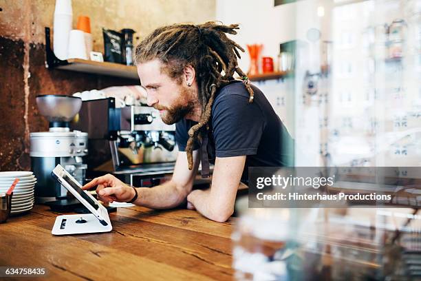 young man behind the counter of a café - checkers - fotografias e filmes do acervo