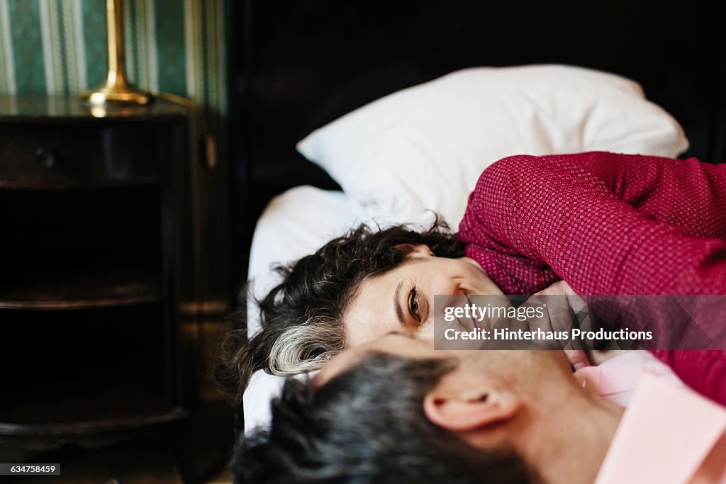Loving mature couple in a hotel bed.