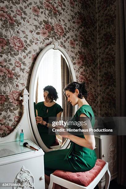 woman sitting in front of a romantic mirror. - bedroom mirror stock-fotos und bilder