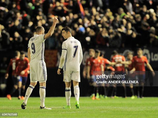 Real Madrid's French forward Karim Benzema speaks with teammate Portuguese forward Cristiano Ronaldo after a goal by Osasuna during the Spanish...