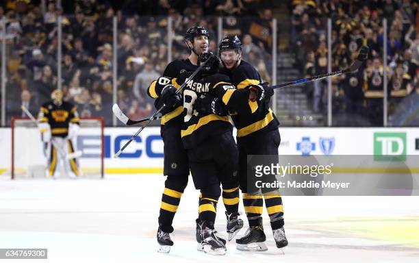 David Pastrnak of the Boston Bruins celebrates with Brandon Carlo and Zdeno Chara after scoring against the Vancouver Canucks during the third period...