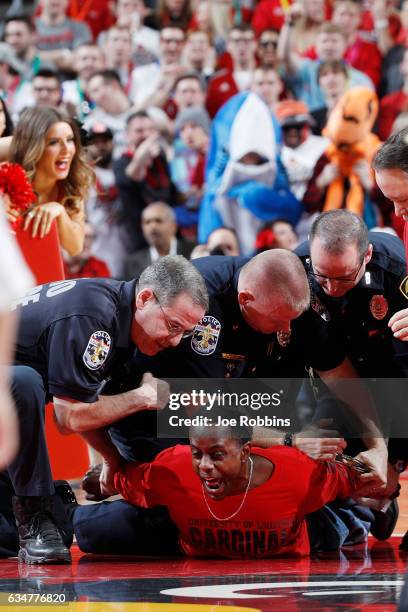 Louisville Cardinals fan is subdued by police after running onto the floor in the first half of the game against the Miami Hurricanes at KFC YUM!...