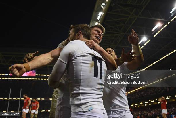 Elliot Daly of England is congratulated by teammates Nathan Hughes and Owen Farrell of England after scoring the match winning try during the RBS Six...