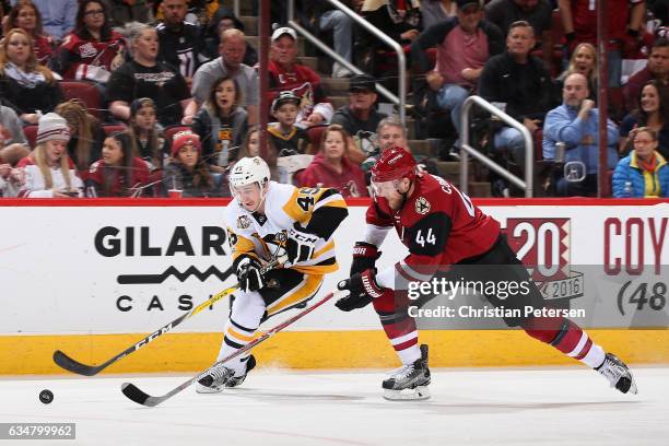 Josh Archibald of the Pittsburgh Penguins skates with the puck ahead of Kevin Connauton of the Arizona Coyotes during the second period of the NHL...