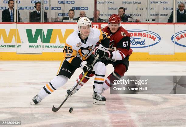 Josh Archibald of the Pittsburgh Penguins skates with the puck as Lawson Crouse of the Arizona Coyotes defends during the third period at Gila River...