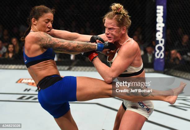 Holly Holm exchanges punches with Germaine de Randamie of The Netherlands in their women's featherweight championship bout during the UFC 208 event...