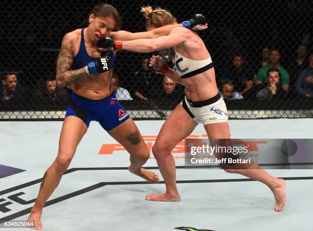 Holly Holm punchess Germaine de Randamie of The Netherlands in their women's featherweight championship bout during the UFC 208 event inside Barclays...