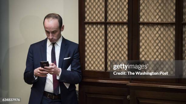 Stephen Miller, White House senior advisor for policy, looks at his phone before a meeting with House and Senate legislators in the Roosevelt Room of...