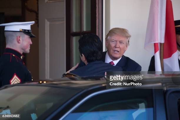 President Donald Trump hugs Japanese Prime Minster Shinz Abe, as he welcomed him to the West Wing of the White House in Washington, DC on February...
