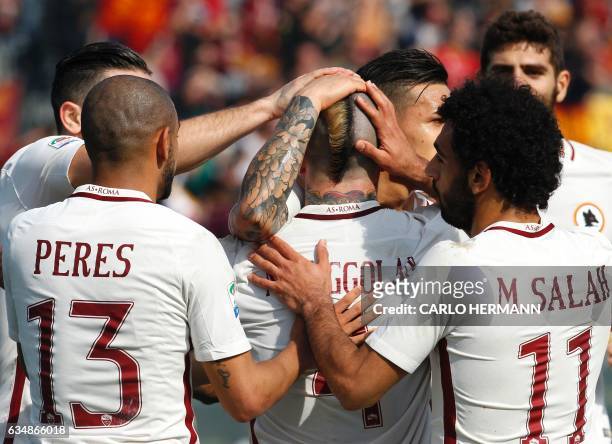 Roma's Belgian midfielder Radja Nainggolan is congratulated by teammates after scoring a goal during the Italian Serie A football match FC Crotone vs...