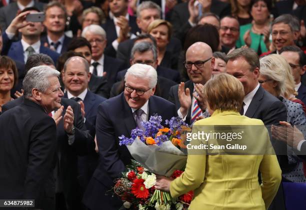 German President-elect Frank-Walter Steinmeier receives applause from outgoing President Joachim Gauck and Chancellor Angela Merkel following...