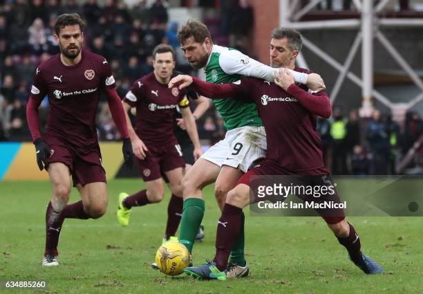 Grant Holt of Hibernian is challenged by Aaron Hughes of Hearts during the Scottish Cup fifth round match between Heart of Midlothian and Hibernian...