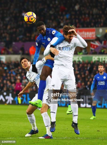 Wilfred Ndidi of Leicester City jumps between Fernando Llorente and Jack Cork of Swansea City during the Premier League match between Swansea City...