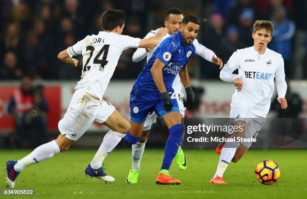 Riyad Mahrez of Leicester City takes on Jack Cork , Martin Olsson and Tom Carroll of Swansea City during the Premier League match between Swansea...