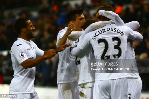 Swansea City's Swedish defender Martin Olsson celebrates with teammates after scoring their second goal during the English Premier League football...