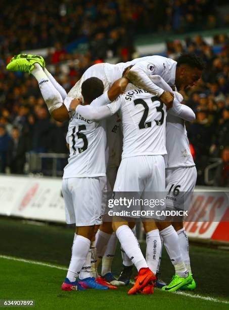 Swansea City's Swedish defender Martin Olsson celebrates with teammates after scoring their second goal during the English Premier League football...