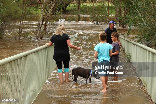 Sightseers stand on Maali bridge, as flood waters are seen in the Swan River on February 12, 2017 in the suburb of Herne Hill in Perth, Australia....