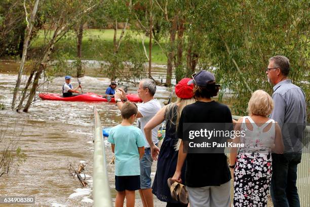 Sightseers stand on Maali bridge, as flood waters are seen in the Swan River on February 12, 2017 in the suburb of Herne Hill in Perth, Australia....