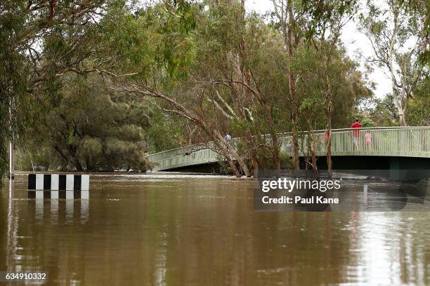 Sightseers stand on Maali bridge, as flood waters are seen in the Swan River on February 12, 2017 in the suburb of Herne Hill in Perth, Australia....