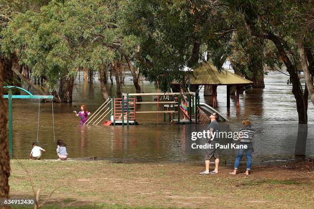 Children play on submerged playground equipment at Lilac Hill as flood waters rise in the Swan River on February 12, 2017 in the suburb of West Swan...