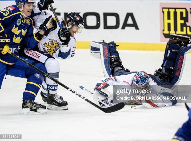 Finish goalkeeper Mikko Koskinentar reaches for the puck in front of Finland's Mikko Kousa Sweden's Fredrik Handmark during the Sweden Hockey Games...