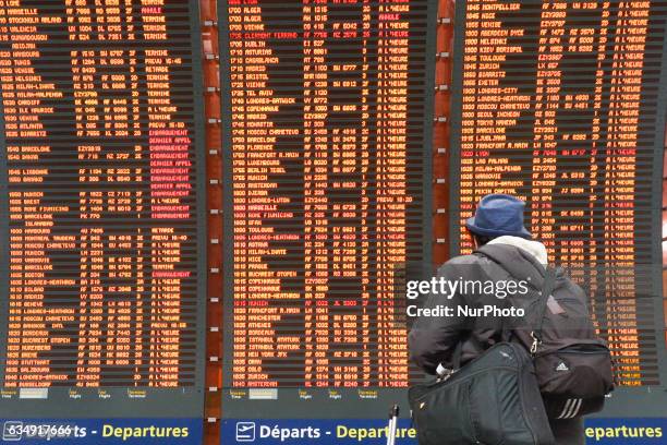 Man is checking his flight on the Departures board at the Terminal 2 of Paris Charles de Gaulle Airport. On Sunday, 12 February in Paris, France.