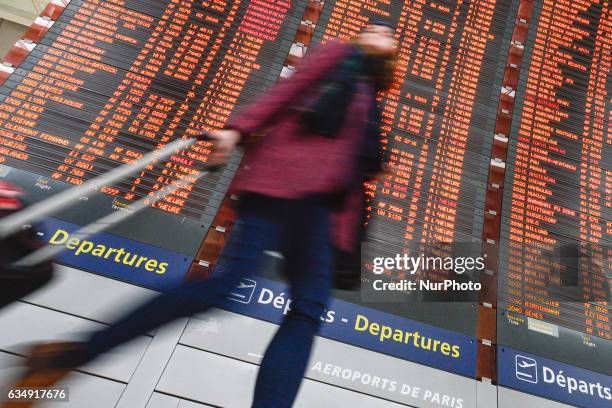 Personne passes in front of the Departures board at the Terminal 2 of Paris Charles de Gaulle Airport. On Sunday, 12 February in Paris, France.