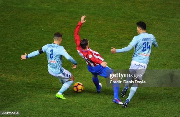 Fernando Torres of Club Atletico de Madrid loses his balance while being tackled by Hugo Mallo and Facundo Roncaglia of RC Celta de Vigo during the...