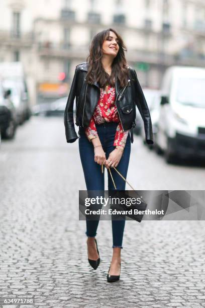 Sarah Benziane, fashion blogger from Les Colonnes de Sarah, wears a Zara black leather jacket, a Zara red top with floral print, Newlook blue denim...