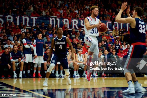 St. Mary's Gaels guard Jordan Ford passes mid-air in front of Gonzaga Bulldogs forward Zach Collins and Gonzaga Bulldogs guard Jordan Mathews during...