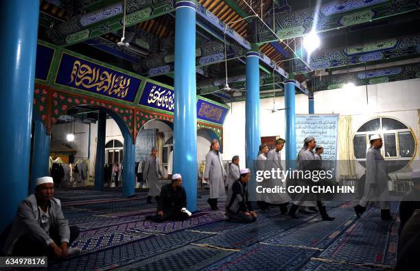 This picture taken on September 19, 2015 shows Chinese Hui Muslim men arriving for evening prayers at the Great Mosque of Tongxin, located some 200...