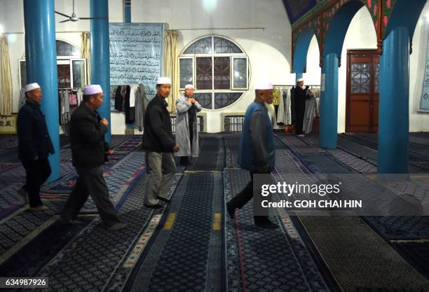 This picture taken on September 22, 2015 shows Chinese Hui Muslim men arriving for evening prayers at the Great Mosque of Tongxin, located some 200...