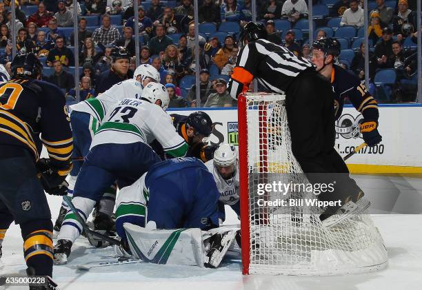 Referee Kelly Sutherland jumps onto the night to keep an eye on play between the Vancouver Canucks and Buffalo Sabres during an NHL game at the...