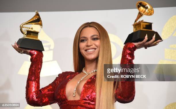 Singer Beyonce poses with her Grammy trophies in the press room during the 59th Annual Grammy music Awards on February 12 in Los Angeles, California....