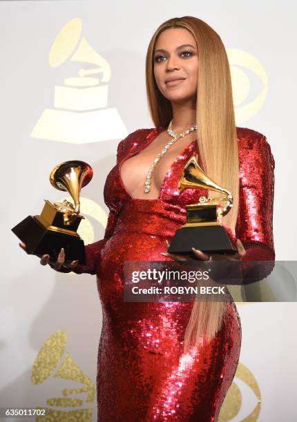 Singer Beyonce poses with her Grammy trophies in the press room during the 59th Annual Grammy music Awards on February 12 in Los Angeles, California....