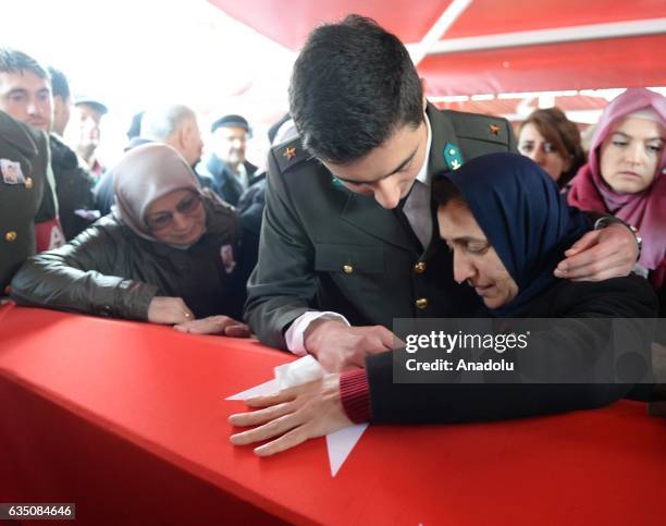 Lieutenant Furkan Yayla's mother Hulya Yayla and brother Talha Yayla wearing his brother's military uniform mourn over the Turkish flag-draped coffin...