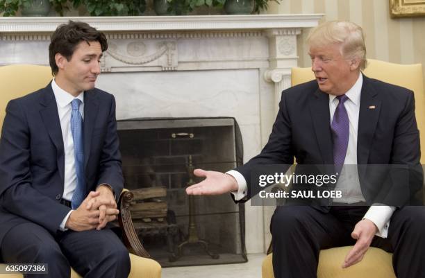 President Donald Trump and Canadian Prime Minister Justin Trudeau shake hands during a meeting in the Oval Office of the White House in Washington,...