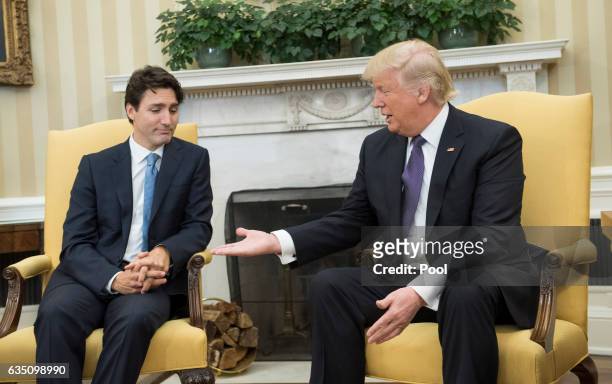 President Donald Trump extends his hand to Prime Minister Justin Trudeau of Canada during a meeting in the Oval Office at the White House on February...