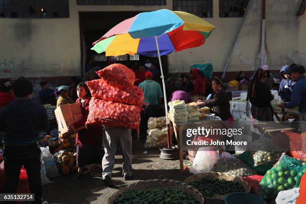 Oorter carries sacks of potatoes from a vegetable market on February 11, 2017 in Almolonga, Guatemala. The Mayan town in the western highlands...