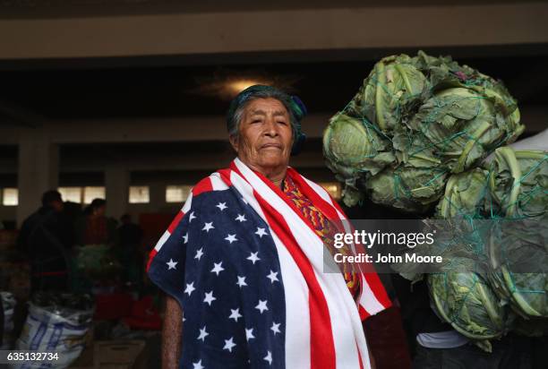 Maria Isabel Luna wears an American towel for warmth over her traditional Mayan dress while working at a vegetable market on February 11, 2017 in...