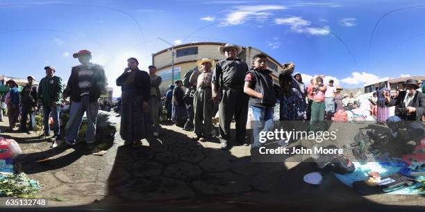 Potential buyers watch as herbal remedy salesman Wilmer Ruiz shows off his formula to people at a vegetable market on February 11, 2017 in Almolonga,...